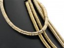 Pierced, sparkling, golden haematite discs