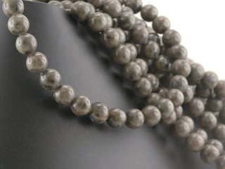 Petites boules de feldspath iridescentes, brun-gris, perforées