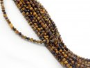 Pierced tigers eye beads with facets in golden brown