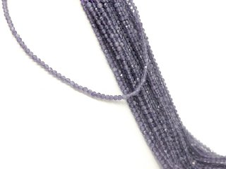 A shimmering purple agate strand above a white bust with further gemstone strands behind it