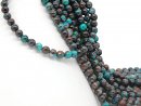 Pierced, turquoise-coloured chrysocolla spheres