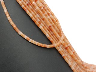 Orange-coloured, pierced calcite discs
