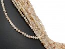 Small, drilled quartz spheres with facets in peach tones