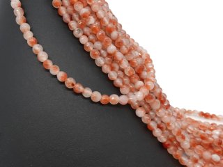 Orangefarbene, durchbohrte Quarzitkugeln