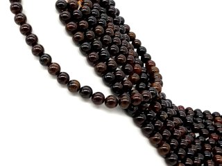 Rote und orangefarbene, durchbohrte Granatkugeln