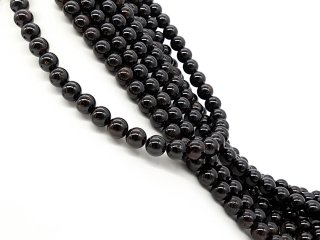 durchbohrte, dunkelrote Granatkugeln