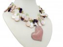 A necklace made of pearls and gemstones with a large rose quartz heart