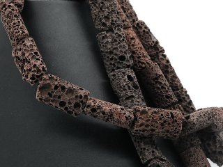 Cylindres de lave bruns, percés et de forme ovale