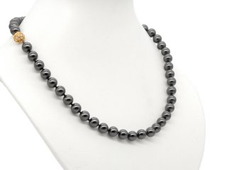 Black necklace made from shell beads with a gold-coloured clasp