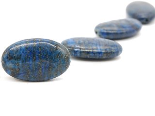 A pierced oval lapis lazuli disc