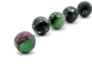 Boule de pierre précieuse facettée en vert et noir, en partie magenta