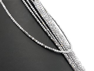 Faceted, pierced spheres made of hematite in grey